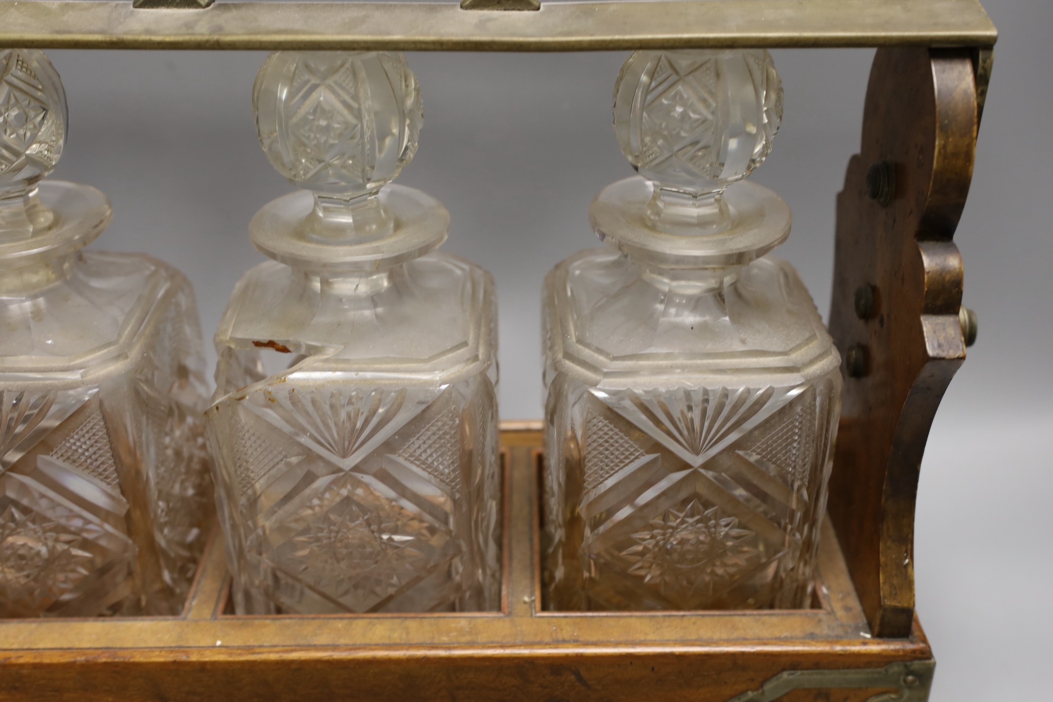 A Victorian Betjemann’s patent oak cased three bottle tantalus (a.f.), 42cms wide at base